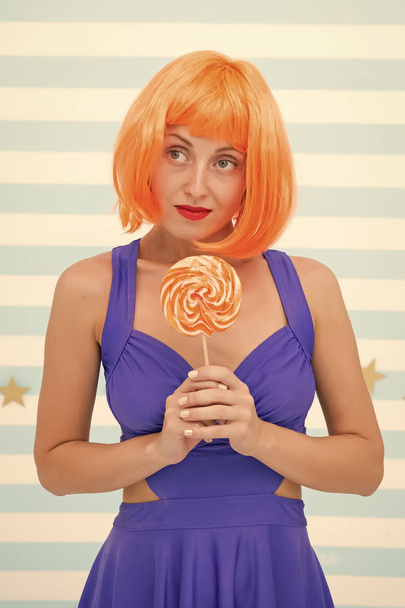 Crazy girl in playful mood. Fashion girl with orange hair having fun. happy pinup model with lollipop in hand. Cool girl with lollipop. Sexy woman. thinking. sweet dreams. party time. - Foto, afbeelding