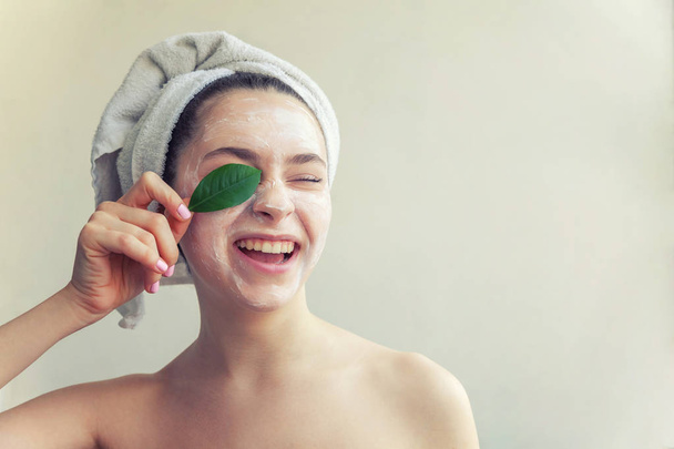Cara de mulher com folha verde e creme ou máscara nutritiva
 - Foto, Imagem