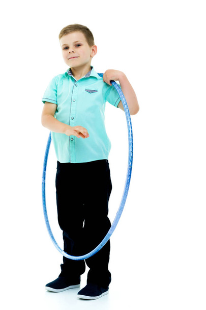 A little boy is playing with a hoop. - Фото, зображення