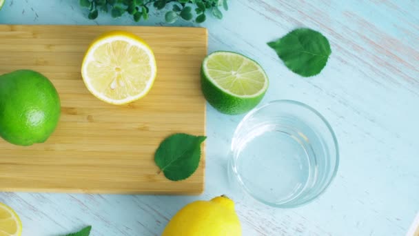Trancher la lime et le citron sur la surface de la cuisine en bois avec du verre. Fermer les images 4k
. - Séquence, vidéo