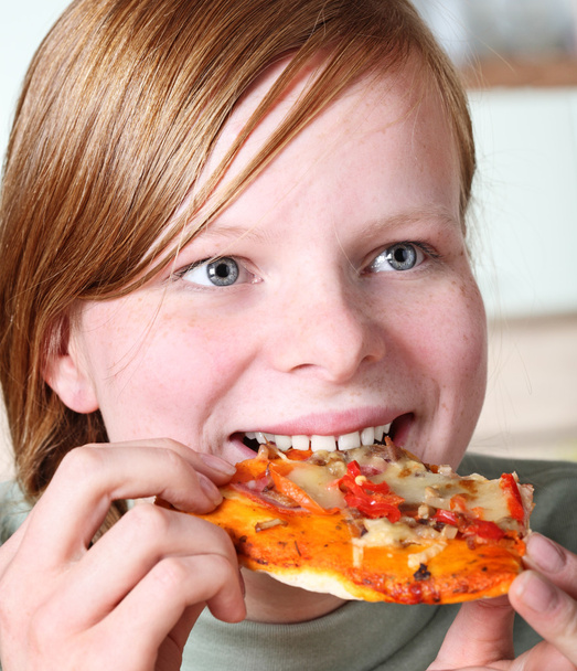 Teenage girl eating pizza - 写真・画像