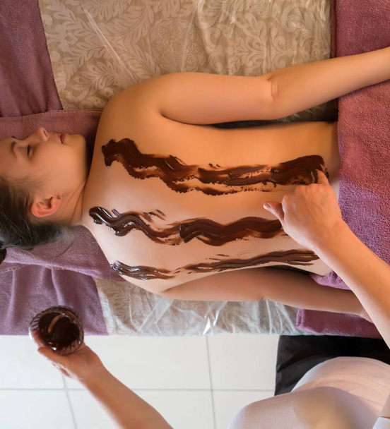 Chocolate massage. Top view of girl rest in spa - Foto, imagen