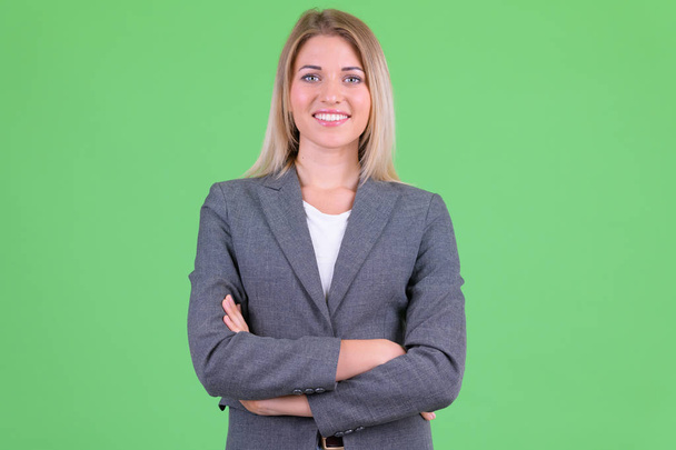 Happy young beautiful blonde businesswoman smiling with arms crossed - Fotó, kép