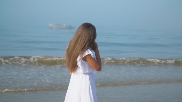 meisje in een witte jurk wandelingen langs de zee - Video