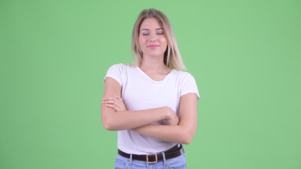 Happy young beautiful blonde woman smiling with arms crossed - Footage, Video
