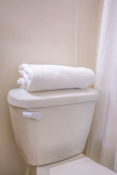 Zbliżenie toalety w łazience z zagiętym ręcznikiem na szczycie zbiornika - Zdjęcie, obraz