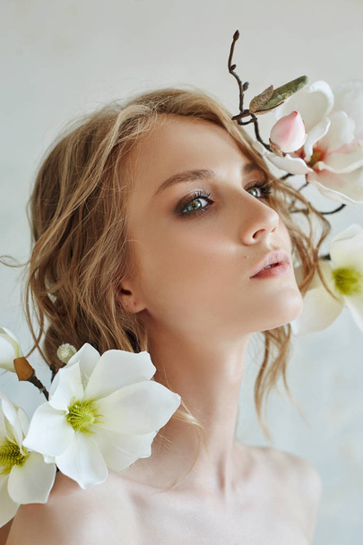 Art Girl blonde flowers near the face. Natural cosmetics for ski - Photo, Image