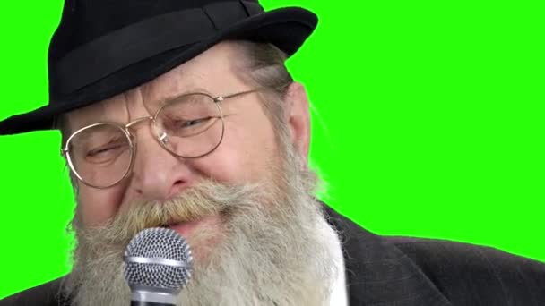 A szakállas ember bezárása mikrofonnal zöld képernyőn. - Felvétel, videó
