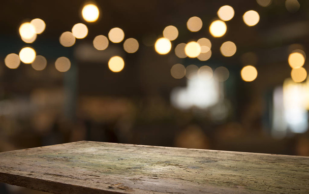 Empty wood table top on blur light gold bokeh of cafe restaurant in dark background - Photo, Image