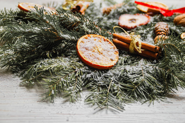 Szilveszteri ünnep dekorációk. Handmade Karácsonyi koszorú fenyő ágak diófélék, fahéj és szárított gyümölcsök leporolta a mesterséges hó. Alakformálás - Fotó, kép