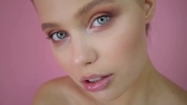 Hermosa chica en el fondo del estudio, concepto de belleza, en el fondo rosa
 - Metraje, vídeo