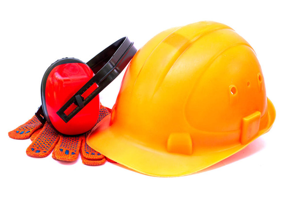 Апельсиновый шлем для строителя как средство защиты на строительной площадке на белом фоне
. - Фото, изображение