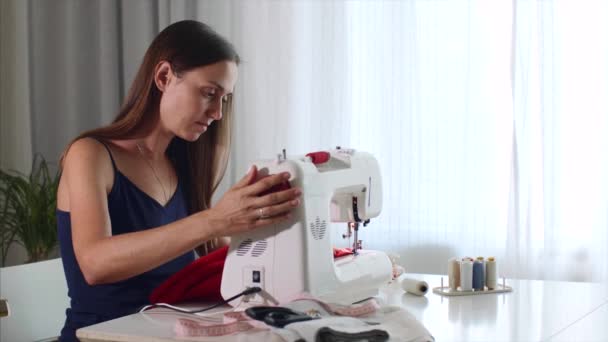 Samostatně výdělečně zaměstnaná mladá žena přizpůsobit pracovní a šicí tkaniny na šicí stroje. - Záběry, video
