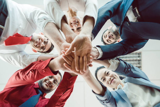 Team aus unterschiedlichen Geschäftsleuten stapelt die Hände zusammen - Foto, Bild