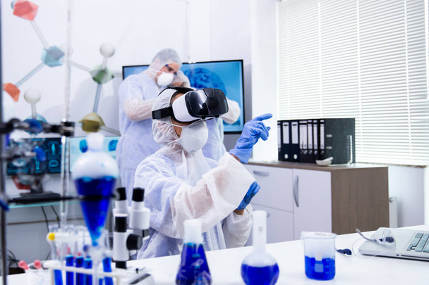 Femme scientifique faisant des tests expérimentaux à l'aide de lunettes de réalité virtuelle
 - Photo, image