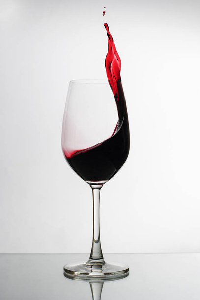 Červené víno šplouchnutí po boku skleněného vína - Fotografie, Obrázek