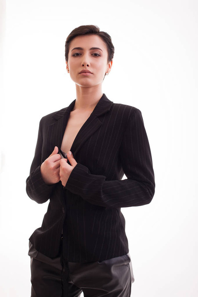 Prachtige jonge vrouw het dragen van een zwart jasje geïnsoliteerd over witte achtergrond - Foto, afbeelding