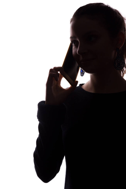 Mujer joven llamada telefónica - mira hacia adelante, silueta aislada retrato
 - Foto, Imagen