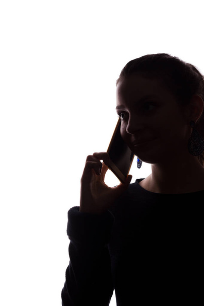 Young woman phone call - looks straight ahead, portrait isolate silhouette - Photo, Image