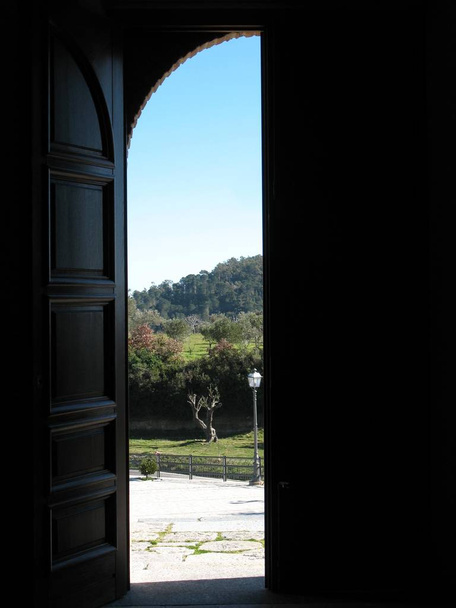 Дверь церкви (Святилище Марии Милосердия в Даволи - Калабрия) с видом на ландшафт снаружи
 - Фото, изображение