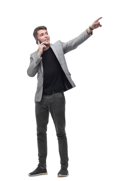 handsome man talking to a mobile phone and pointing to a copy of the space - Фото, изображение