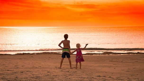 crianças de pé em uma praia
 - Foto, Imagem