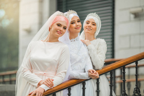 three beautiful young women in national festive white muslim dresses - Valokuva, kuva