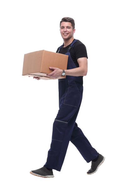 smiling worker with cardboard box stepping forward. isolated on white - Zdjęcie, obraz