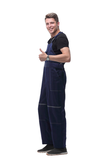 smiling man in overalls showing thumb up .isolated on white - Fotografie, Obrázek