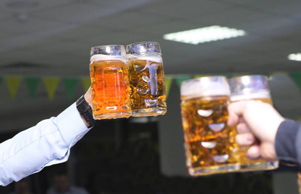 ビールグラスは、挨拶男性の友人パーティーを手に - 写真・画像