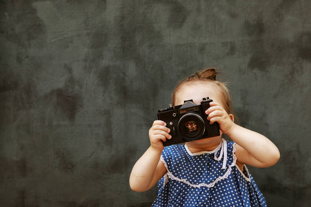 Pieni tyttö kauniissa mekossa oppia ottamaan kuvia
 - Valokuva, kuva