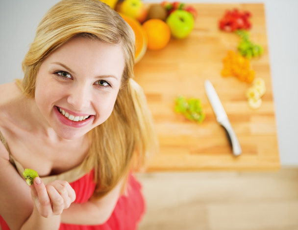 Portrait of smiling young woman making fruits salad - Φωτογραφία, εικόνα