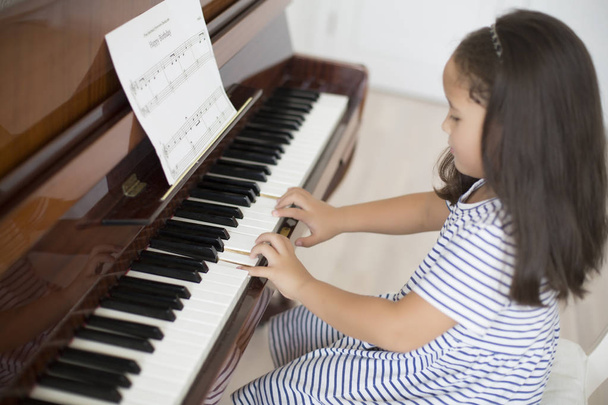 Kazah ázsiai kislány tanulás zongorázni - Fotó, kép