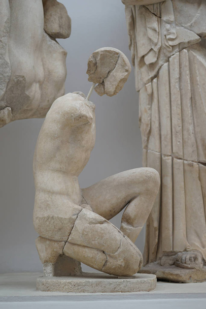Estátua de um homem ajoelhado no sítio arqueológico de Olímpia
 - Foto, Imagem