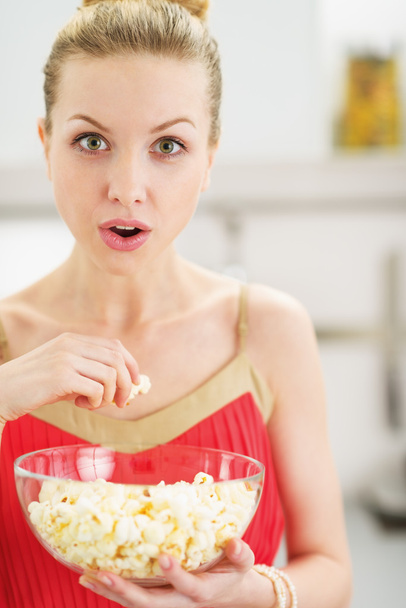 Portrait of young woman eating popcorn - 写真・画像
