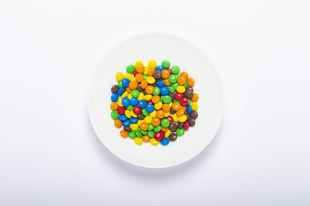 Colorate pillole di cioccolato caramelle isolate su sfondo bianco. Vista dall'alto
 - Foto, immagini