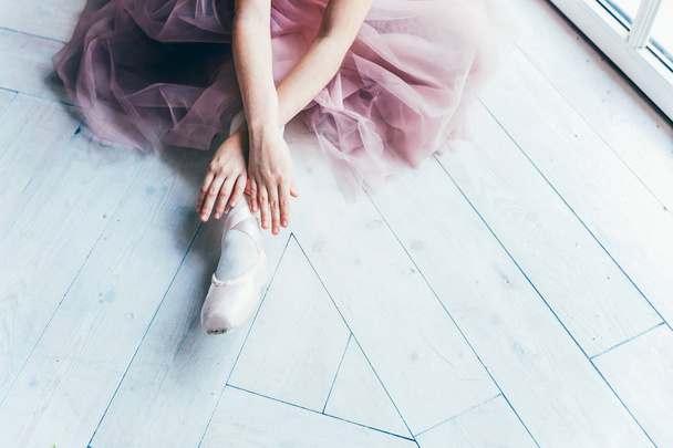 Балерина руки ставить Пуанти на ногу в танц-клас - Фото, зображення