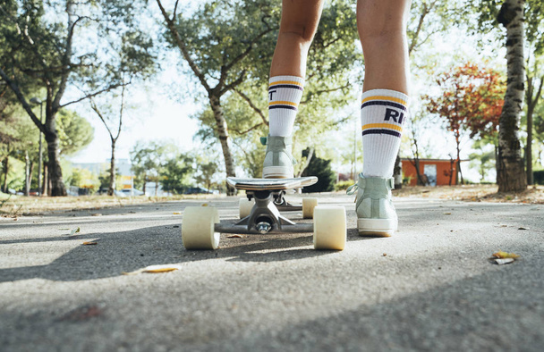 Τα πόδια της εφηβικής ηλικίας κορίτσι με longboard - Φωτογραφία, εικόνα