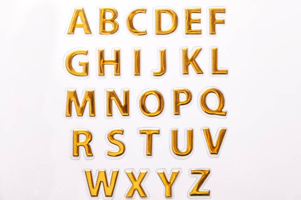 Set of shiny golden glossy letters, isolated on white background. - Photo, Image