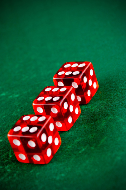 drie rode dobbelstenen in het casino - Foto, afbeelding