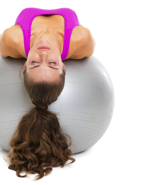 Young woman laying on fitness ball - Фото, зображення