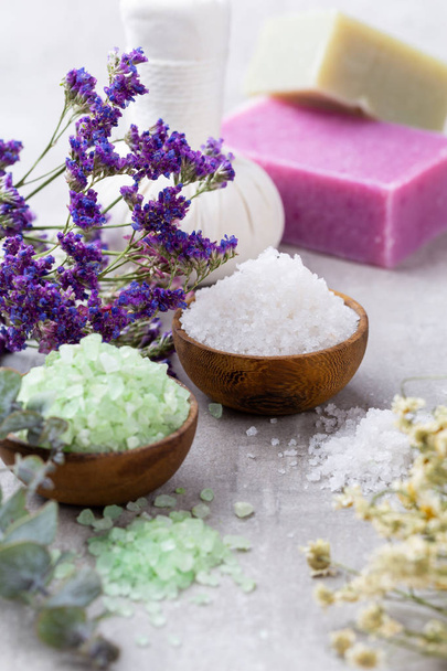 Sea salt in bowl, aroma oil in bottles, Wellness and flowers on  - Photo, Image