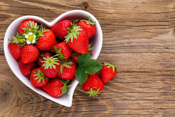 Strawberry heart. Fresh strawberries in plate on white wooden ta - Foto, Imagen