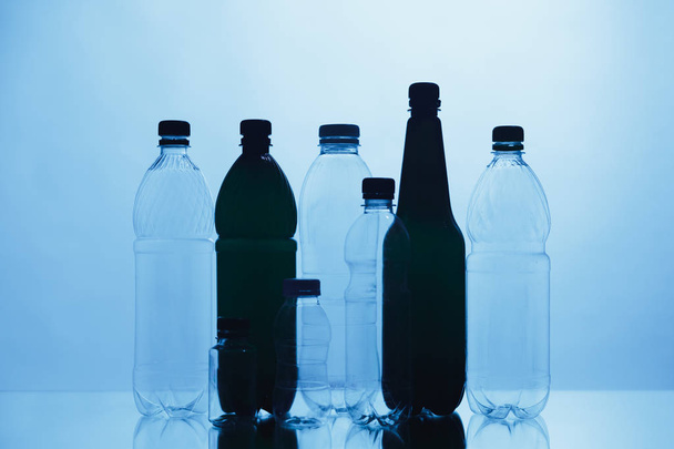 prázdné plastové obrysy lahví na modrém pozadí - Fotografie, Obrázek