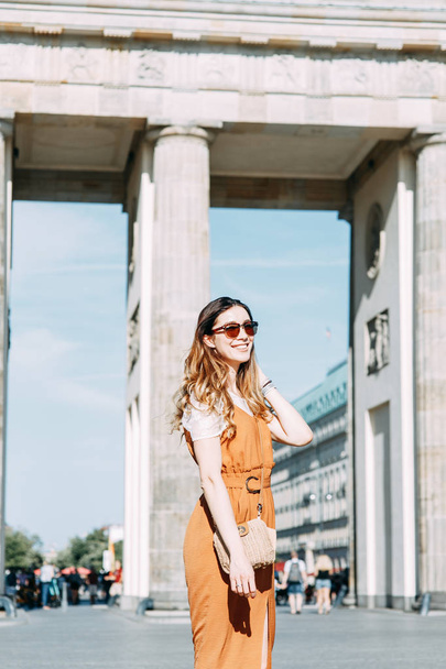  walk around Berlin with a blogger. smiling girl traveler at the Brandenburg gate. - Фото, изображение
