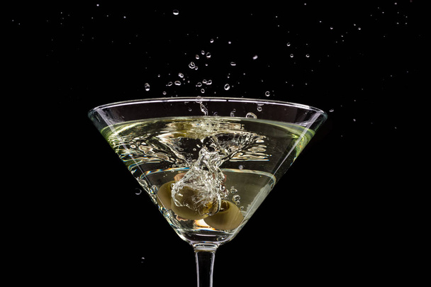 glass of martini with olives and ice on a black background and fire - Foto, immagini