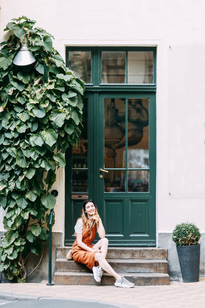  travel blogger exploring old buildings. cheerful young girl in the yard with greenery. - 写真・画像