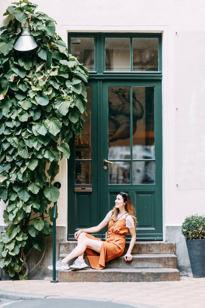  travel blogger exploring old buildings. cheerful young girl in the yard with greenery. - Foto, imagen