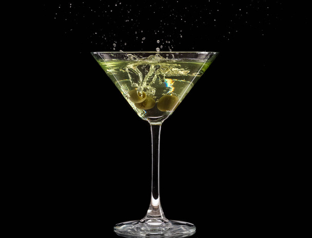 glass of martini with olives and ice on a black background and fire - Fotografie, Obrázek