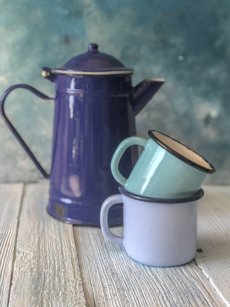 blue colored enamel teapot and mugs on a wooden table - Photo, Image